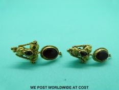 A pair of Roman yellow metal earrings set with garnets