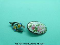 A hallmarked silver and enamel brooch with floral decoration and a brooch in the form of a wishbone