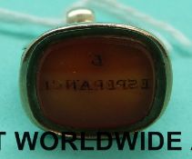A yellow metal intaglio fob with two snakes making up the loops,