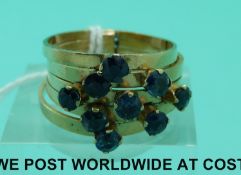 A yellow metal ring set with round cut sapphires,