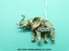 A yellow metal brooch in the form of an elephant set with a sapphire, diamonds and rubies (8.