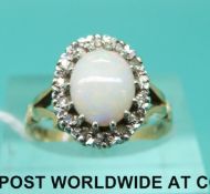 A 9ct gold ring set with an oval opal cabochon surrounded by diamonds (size M)