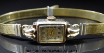 Baume 9ct gold ladies wristwatch with Arabic numerals, two tone face, gold hands and scrolling lugs,