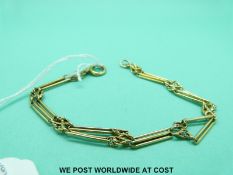 A yellow metal bracelet made up of elongated and knot links (9.