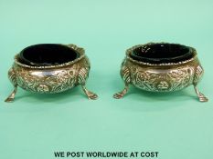 A pair of Victorian hallmarked silver open salts with glass liners raised on hoofed feet, London,