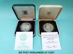 Two Royal Mint cased silver proof crowns comprising 1985 Falkland Islands Mount Pleasant Airport