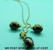 A yellow metal pendant marked 585 set with a cat's eye sapphire cabochon with a matching pair of