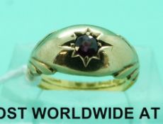 A yellow metal ring set with a garnet,