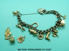A silver charm bracelet with 15 9ct gold/yellow metal charms including a pig, fox etc.