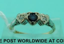 An 18ct gold ring set with a sapphire and two diamonds in a platinum heart setting (size M)