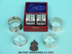 Four hallmarked silver napkin rings and a hallmarked silver ARP badge (68g) together with a cased