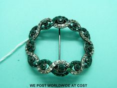 A white metal buckle set with green and clear paste