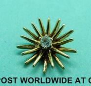 A 9ct gold starburst pendant set with a diamond