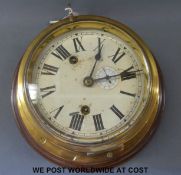 A brass bulkhead ship's clock with Roman numerals on painted dial with subsidiary Arabic seconds