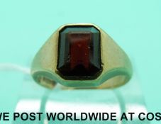 A 9ct gold ring set with an emerald cut garnet (size N)