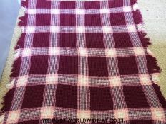 A woven Welsh blanket finished in pink red and white,