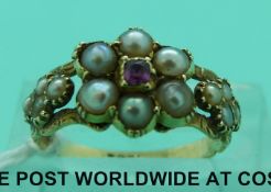 An 18ct gold ring set with a ruby surrounded by seed pearls in a cluster,
