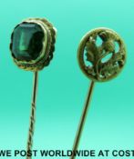 A yellow metal stick pin in the form of a thistle and another yellow metal stick pin set with a