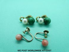 A pair of 9ct gold earrings set with a coral bead to each and a pair of yellow metal earrings set