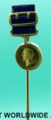 A Victorian yellow metal stick pin in the form of a miniature Wellington commemorative medal set