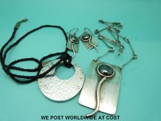 A white metal necklace and matching earrings set with hematite and another silver pendant