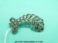 A white metal feather brooch set with paste