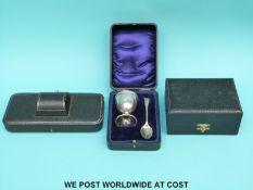 A cased hallmarked silver egg cup and spoon christening set (56g) together with two empty