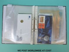 A folder containing a collection of largely £5 coins and first day covers,