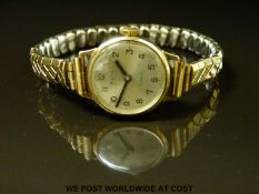 Avia 9ct gold ladies wristwatch with black hands and Arabic numerals, on expanding metal strap,