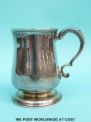 A Georgian hallmarked silver half pint tankard of baluster form with scrolling handle,