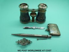 A pair of opera glasses, a white metal vesta, silver pen,
