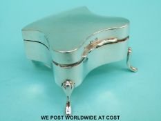A George VI hallmarked silver dressing table trinket box of shaped form raised on four feet,