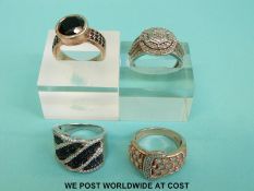 Two silver rings one set with black diamonds the other with diamonds in a cluster together with two