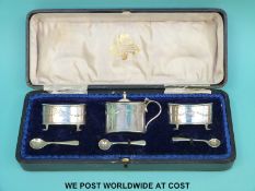 A cased hallmarked silver three piece cruet set with spoons,