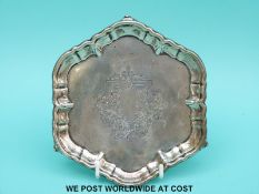 An Edwardian hallmarked silver calling card tray raised on scrolling feet,