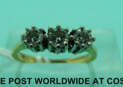 An 18ct gold ring set with three round cut diamonds (Size H)