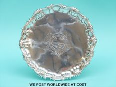 A Georgian hallmarked silver salver or card tray, having shaped edge and raised on three pad feet,