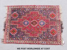 A wool rug with geometric design and guls in each corner (154 x 115cm)