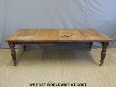 A 19thC oak extending dining table and two leaves,