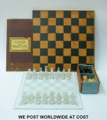 A turned wooden chess set on wooden board together with a clear and frosted glass set on etched
