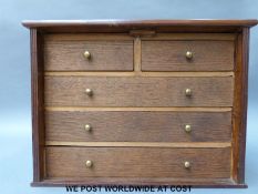 An oak collector's chest of drawers with lockable front flap