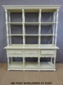 A painted three drawer dresser with shelves above,