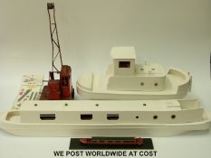 Two wooden part built model boats together with a tin-plate model crane
