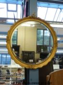 A circular bevelled glass mirror (overall diameter 63cm)