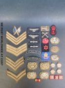 A quantity of WWII and later cloth badges including stripes, regimental insignia etc.