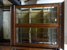 An Edwardian glazed display cabinet raised on tapering legs and spade feet.