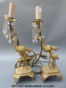 A pair of gilt metal style table lamps in the form of storks