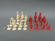 A late 19th/ early 20thC carved bone chess set, one side stained in red,
