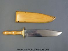 A laminated wood or similar Bowie knife with brass guard,