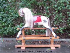 A late 19th early 20th century dapple grey rocking horse with leather saddle and bridle and horse